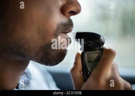 Homme assis à l'intérieur car la prise d'alcool Test Banque D'Images