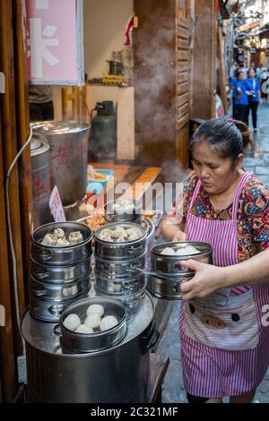 Femme vendant de délicieux boulettes traditionnelles chinoises Banque D'Images