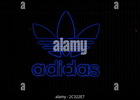 Logo Adidas Originals néon. Arrière-plan noir. Banque D'Images