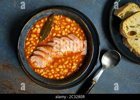 Ragoût de haricots cuits avec sauce tomate et saucisse aux herbes Banque D'Images