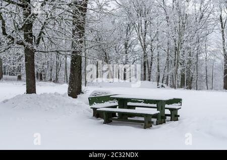 Table de pique-nique en bois avec bancs après les fortes chutes de neige Banque D'Images