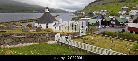 La petite ville de Haldarsvik avec l'église octogonale et vue sur l'Atlantique, Feroeer, Danemark Banque D'Images