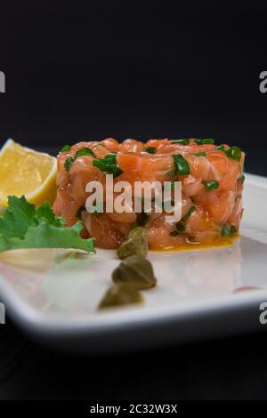 Tartare de saumon frais avec la chaux et les câpres on white plate Banque D'Images