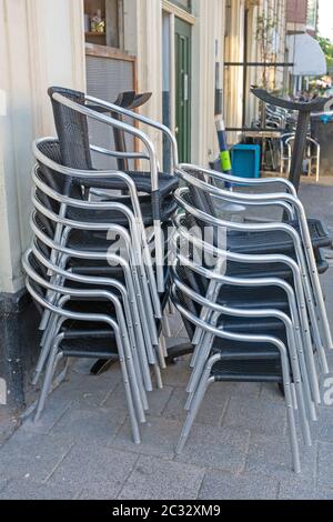 Chaises de métal empilées en face de Cafe Banque D'Images