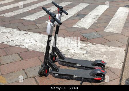 Des scooters électriques à louer à larges feuilles dans la rue Ville Banque D'Images