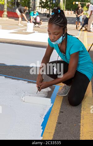 Detroit, États-Unis. 17 juin 2020. Detroit, Michigan - avec l'appui de la ville de Detroit, les adolescents ont peint « L'ÉNERGIE AUX GENS » sur Woodward Avenue au centre-ville. Le projet intervient dans le cadre de semaines de manifestations contre la violence policière et le meurtre de George Floyd et d'autres Afro-Américains. Crédit : Jim West/Alay Live News Banque D'Images