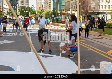 Detroit, États-Unis. 17 juin 2020. Detroit, Michigan - avec l'appui de la ville de Detroit, les adolescents ont peint « L'ÉNERGIE AUX GENS » sur Woodward Avenue au centre-ville. Le projet intervient dans le cadre de semaines de manifestations contre la violence policière et le meurtre de George Floyd et d'autres Afro-Américains. Crédit : Jim West/Alay Live News Banque D'Images