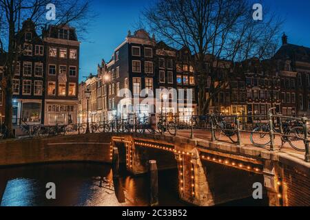 Amsterdam la nuit, pont sur le canal d'eau avec lumières du soir et maisons anciennes, Amsterdam, pays-Bas. Banque D'Images