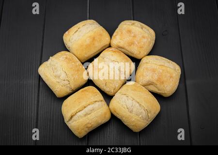 pains de blé croustillants, dorés et fraîchement préparés, en formation géométrique, d'une boulangerie sur fond gris en bois Banque D'Images