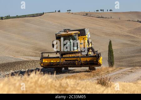 Pienza, Italie - 13 septembre 2011: Moissonneuse-batteuse pendant la récolte et le paysage rural de la Toscane. Italie Banque D'Images