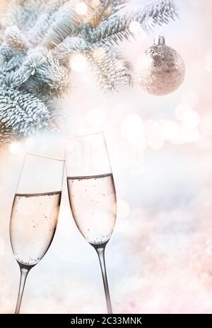 Joyeux noël et une bonne année. Champagne et sapin de noël devant un paysage d'hiver abstrait et tendre avec bokeh festif. Arrière-plan vertical pour c Banque D'Images