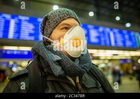 Homme portant un masque respiratoire pour la protection de la santé à un aéroport ou une gare ferroviaire à Banque D'Images