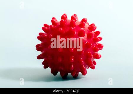 Jouet de chien de boule rouge pour ronger isolé sur un fond bleu clair. Banque D'Images