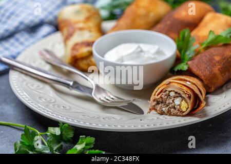 Crêpes fines faites maison avec de la viande, des oignons et des œufs. Banque D'Images