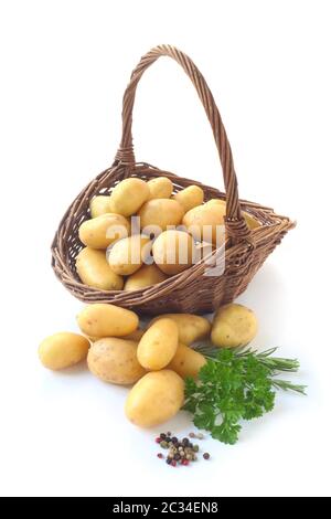 Les pommes de terre crues dans un panier en osier Isolated On White Banque D'Images