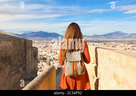 Tourisme à Alicante, Espagne. Vue arrière de voyageur fille qui marche sur le château de Santa Barbara enjoying view de la ville d'Alicante, Espagne. Jeune femme backpacker Banque D'Images