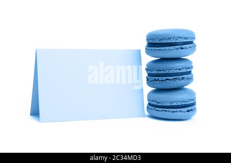 Close up pile de pâtisserie macaron bleu traditionnel français cookies (macarons, macaroni) avec du papier signer isolé sur fond blanc, low angle view Banque D'Images