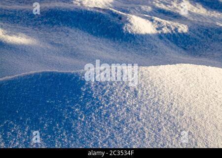 Neige fraîche en hiver par temps ensoleillé, détails sur la nature et la neige avec ombres de différentes surfaces et objets Banque D'Images