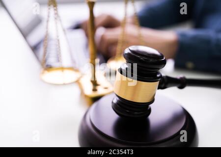 Close-up of Gavel et la justice d'en face du juge Using Laptop Banque D'Images