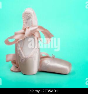 Le ballet des chaussons chaussures de danse avec un arc de rubans joliment pliées sur fond sombre Banque D'Images