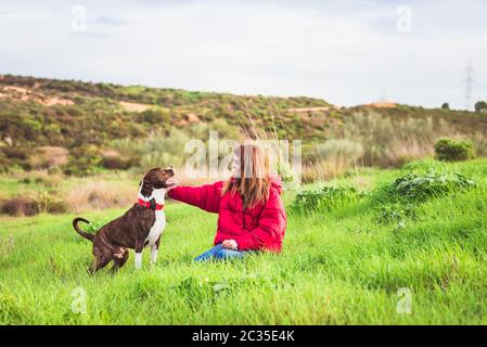 Jeune femme assise avec un terrier américain du Staffordshire Banque D'Images