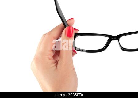 Main féminine tenant des lunettes à cadre noir isolées sur fond blanc Banque D'Images