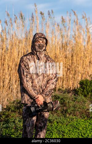 Photographe naturaliste en action, de camouflage et de la caméra, dans le désert. Banque D'Images