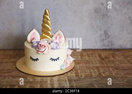 Magnifique gâteau brillant sous forme de licorne aux fleurs de couleur crème Banque D'Images