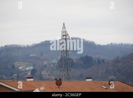 une tour de ligne de transmission haute tension électrique et des antennes satellites sur le toit Banque D'Images