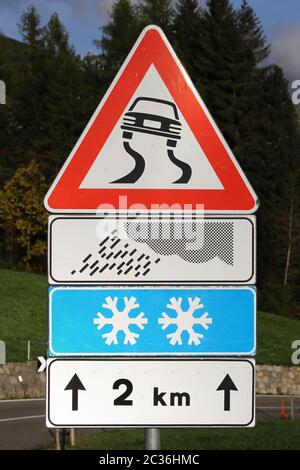 Attention à la signalisation routière risque de glisser sous la pluie et la neige Banque D'Images