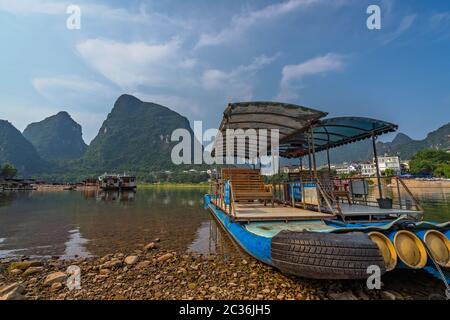 Yangshuo, Chine - Août 2019 : petits bateaux touristiques et les pêcheurs sur la rive de la rivière Li, le traversier point dans Yangshuo Banque D'Images
