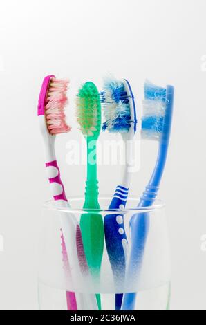 Vieille brosse à dents dans un verre coloré Banque D'Images