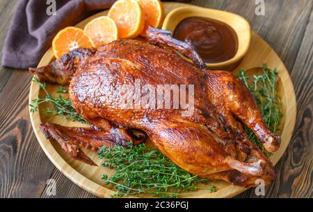 Le canard au four avec du thym et des oranges sur plateau en bois Banque D'Images