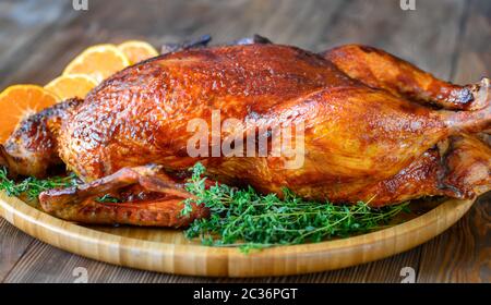 Le canard au four avec du thym et des oranges sur plateau en bois Banque D'Images