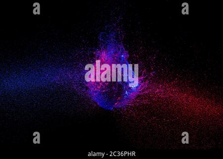 La photographie à haute vitesse. image de l'explosion d'un ballon rempli d'eau et prises au moment exact de l'impact. bleu et violet s'allume. Banque D'Images