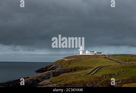 Galley Head, Cork, Irlande. 19 juin 2020.la lumière matinale illumine le phare de Galley Head contre le ciel couvant d'un front météo venant en sens inverse à Co. Cork, Irlande. - crédit; David Creedon / Alamy Live News Banque D'Images