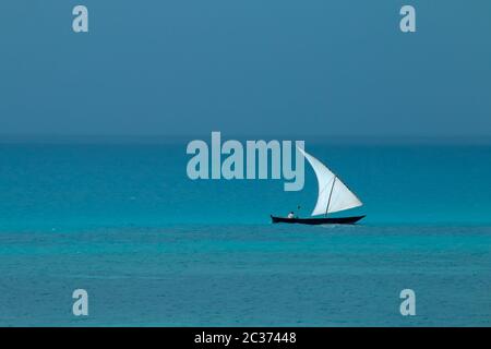 Voilier en bois (dhow) sur l'eau avec ciel nuageux, l'île de Zanzibar Banque D'Images