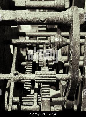 gros plan monochrome d'engrenages et de roues dentées complexes sur des machines en acier rouillé anciennes Banque D'Images