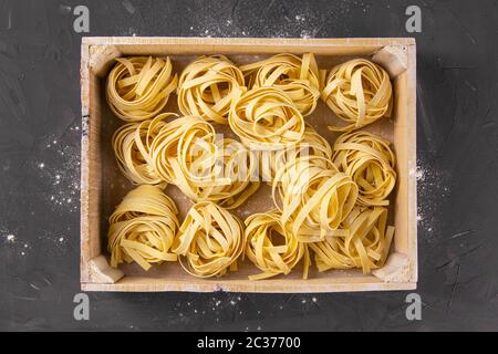 Tagliatelle cru dans une boîte en bois. Vues de dessus Banque D'Images