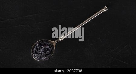 Caviar noir sur un panorama de la cuillère d'argent, tiré du dessus sur un fond sombre avec un endroit pour le texte Banque D'Images