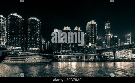 Chongqing, Chine - août 2019 : vue nocturne sur la ville de Chongqing illuminée sur la rivière Jialing et Yangtze avec bateau de luxe à passagers de croisière amarré sur le TH Banque D'Images