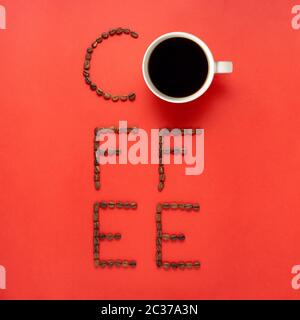 Concept créatif still life photo de tasse à café expresso mug boire avec graines de haricots lettres texte sur fond rouge. Banque D'Images