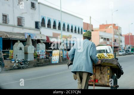 Essaouira, Maroc, février 2019 : ancien musulman vendant des citrons et des fruits en charrette sur le marché traditionnel de la rue au Maroc. Médina de la vieille ville marocaine Banque D'Images