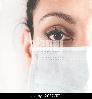 Portrait à moitié face d'une femme médecin dans le masque de protection. Médecin dans un masque médical. Patient, infirmière. Protection contre le coronovirus COVID-19. Coro Banque D'Images