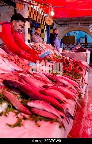 Essaouira, Maroc, février 2019: Vendeur de poisson frais cru, crabes et fruits de mer au marché de la rue dans le port d'Essaouira. Souk marocain Banque D'Images