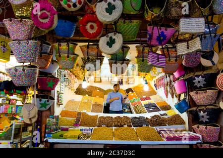 Marrakech, 2019 février : vendeur vendant des épices marocaines traditionnelles et des sacs orientaux colorés dans le souk médina de Marrakech. Marché de rue au Maroc Banque D'Images