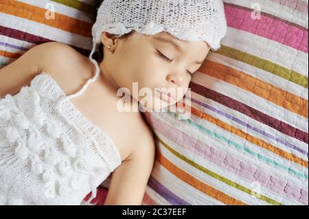 Jolie petite fille dormant sur fond de lit coloré vue rapprochée Banque D'Images