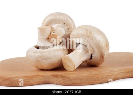 Champignons crus sur le tableau de cuisson isolé sur fond blanc Banque D'Images