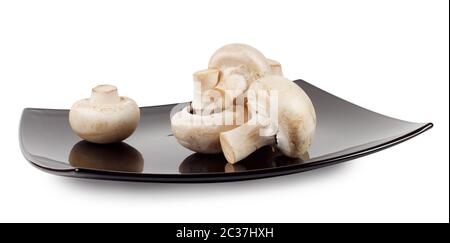 Champignons de Paris sur une plaque noire isolé sur fond blanc Banque D'Images