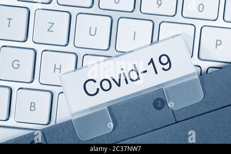 Classeur Covid-19 sur le clavier de l'ordinateur au bureau Banque D'Images